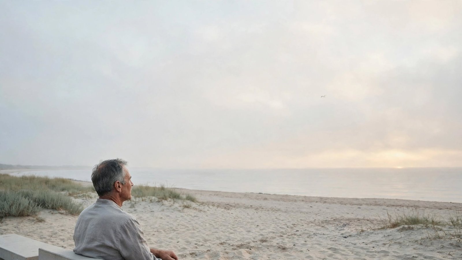 Hombre adulto sentado frente al mar en calma, sintiendo alivio mental