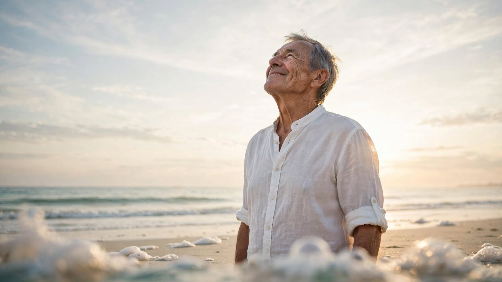 Cómo dejar de pensar tanto: 8 claves para calmar tu mente 4 Persona mayor mirando al cielo en una playa al amanecer, símbolo de renovación y calma mental